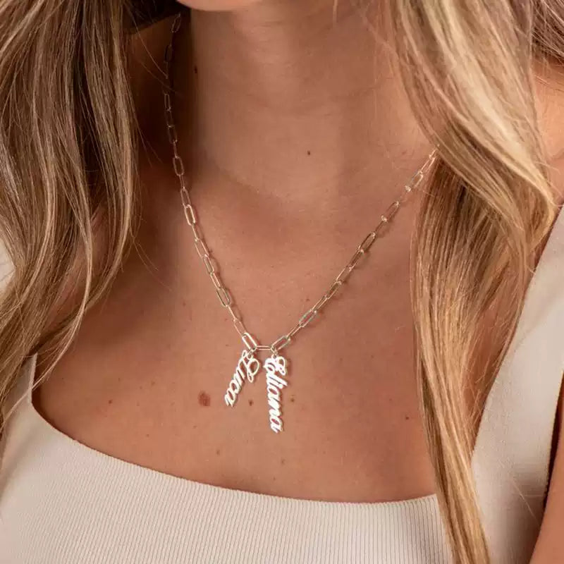 Necklace with name charms worn by a person with long blonde hair. Stainless Steel Name Jewelry. Custom Gift-Personalized. gift for boyfriend / girlfriend. long-distance relationship gift meaningful keepsake. Memory gift. Christmas couple gift. Birthday Gift. Double Name Drop Necklace (Paperclip Chain)
