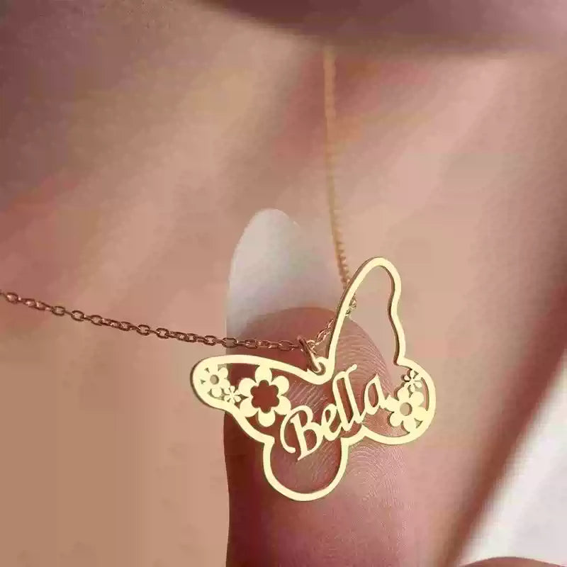 Gold butterfly-shaped necklace with 'Bella' on a blurred background. Stainless Steel Name Jewelry. Custom Gift-Personalized. gift for boyfriend / girlfriend. long-distance relationship gift meaningful keepsake. Memory gift. Christmas couple gift. Birthday Gift. Butterfly & Blossom Name Necklace