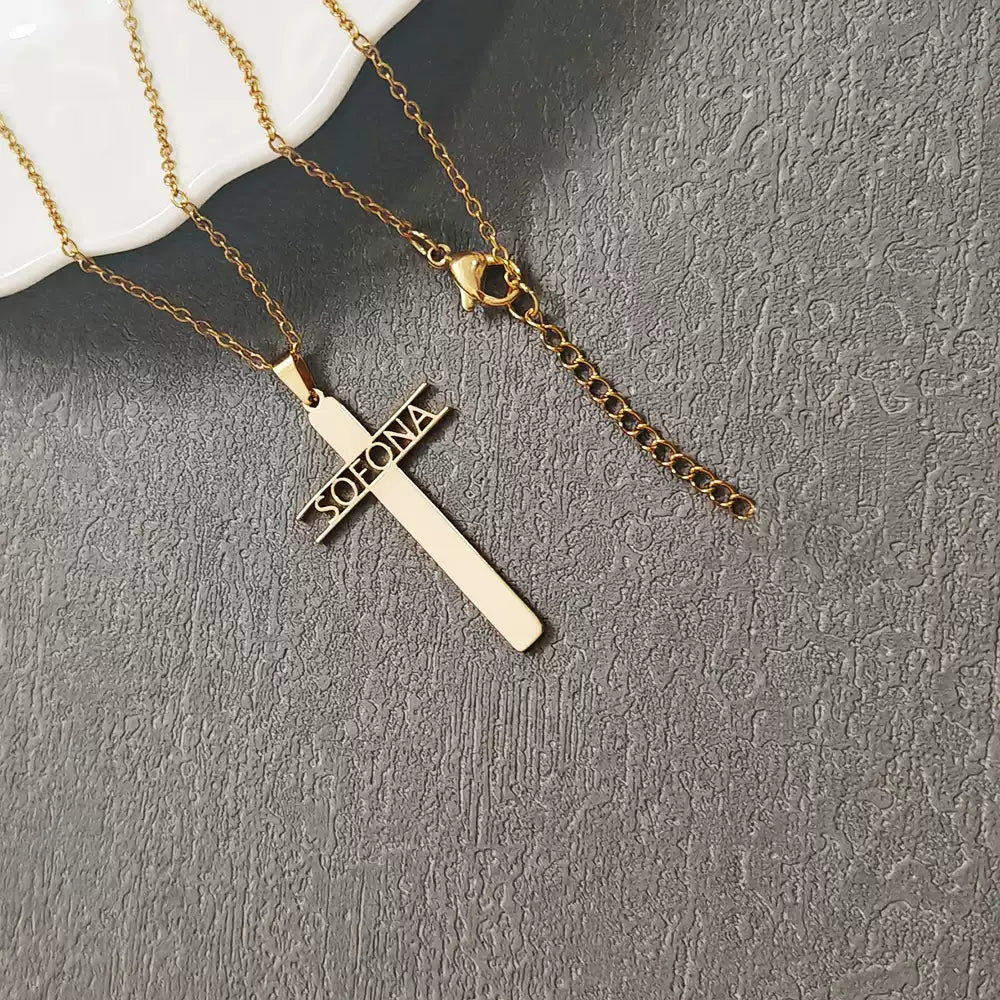 Gold cross necklace with 'Soleone' engraving on a gray surface Stainless Steel Name Jewelry. Custom Gift-Personalized. gift for boyfriend / girlfriend. long-distance relationship gift meaningful keepsake. Memory gift. Christmas couple gift. Birthday Gift. Hollow Letter Cross Necklace