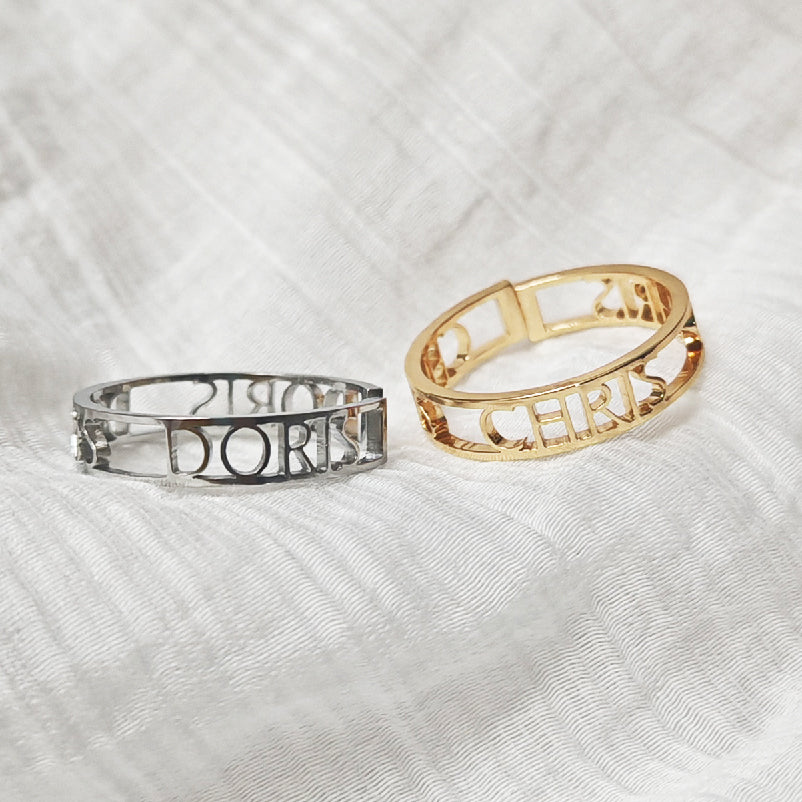 Two bracelets, one silver and one gold, on a textured white background. Stainless Steel Name Jewelry. Custom Gift-Personalized. gift for boyfriend / girlfriend. long-distance relationship gift meaningful keepsake. Memory gift. Christmas couple gift. Birthday Gift. Bold Initial Frame