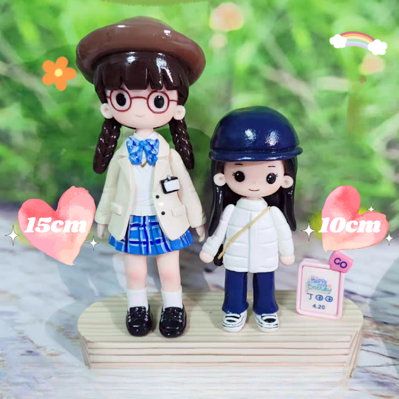 Two small figurines on a wooden stand with measurements indicated. 10cm. 15cm. Personalized couple present. Gift for boyfriend girlfriend. Custom-made. Personalized. Perfect gift idea. Meaningful keepsake. Wedding gift. Anniversary gift. Birthday gift