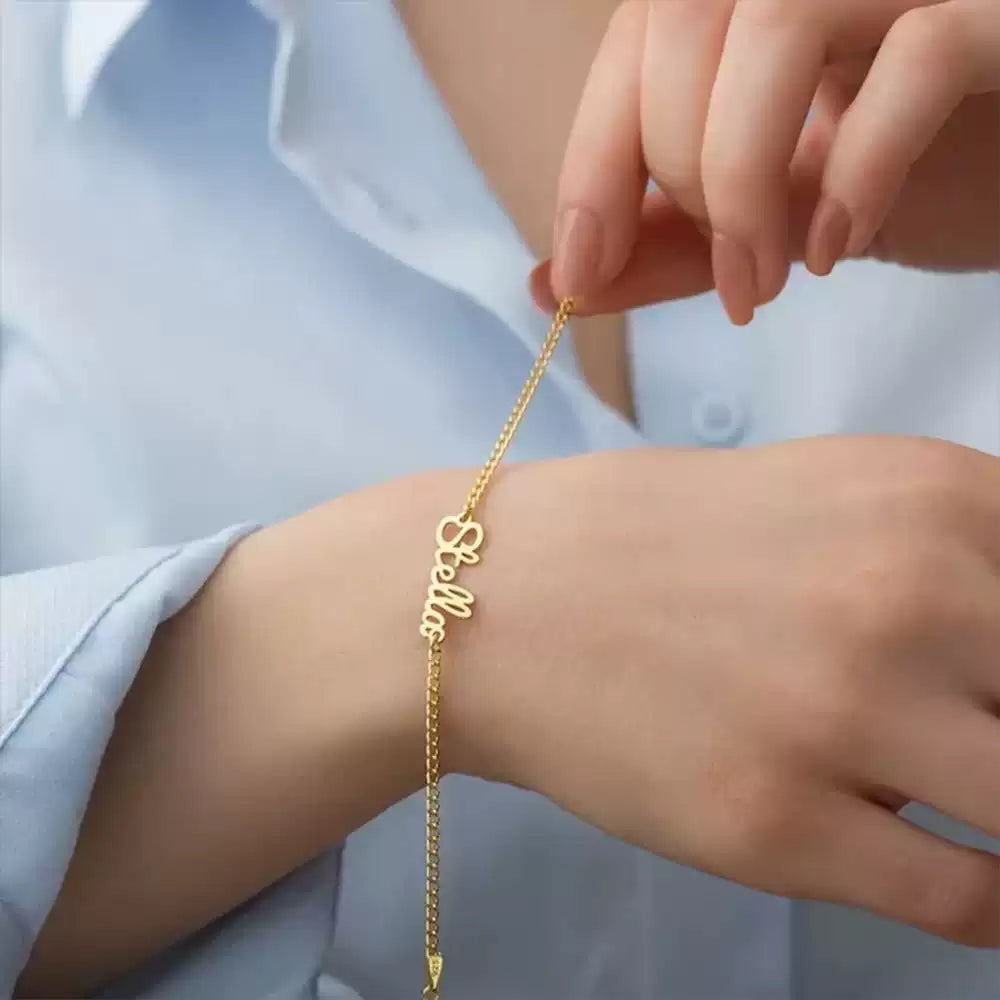 Gold bracelet with 'love' on a wrist against a light blue shirt background. Stainless Steel Name Jewelry. Custom Gift-Personalized. gift for boyfriend / girlfriend. long-distance relationship gift meaningful keepsake. Memory gift. Christmas couple gift. Birthday Gift. 