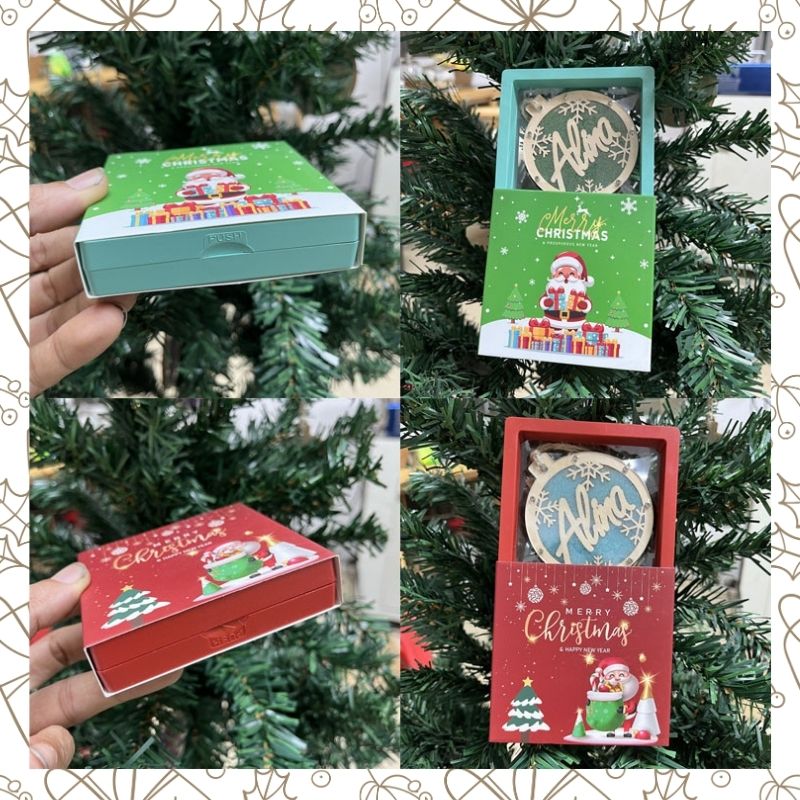 Three Christmas-themed boxes with decorative designs against a Christmas tree background.