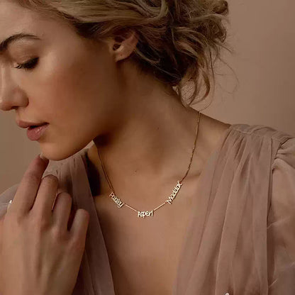 Woman wearing a gold necklace with engraved names against a neutral background. Name wiht Box Chain