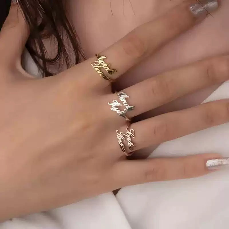 Close-up of a hand wearing three gold rings with cursive text on a white background. Stainless Steel Name Jewelry. Custom Gift-Personalized. gift for boyfriend / girlfriend. long-distance relationship gift meaningful keepsake. Memory gift. Christmas couple gift. Birthday Gift. 