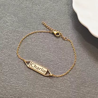 Gold bracelet with 'Charlie' engraving on a gray surface. Hollow Plaque. Stainless Steel Name Jewelry. Custom Gift-Personalized. gift for boyfriend / girlfriend. long-distance relationship gift meaningful keepsake. Memory gift. Christmas couple gift. Birthday Gift. 
