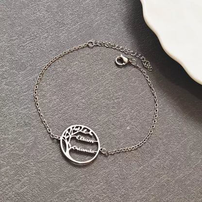 Silver bracelet with tree design and engraved names on a gray surface.  Stainless Steel Name Jewelry. Custom Gift-Personalized. gift for boyfriend / girlfriend. long-distance relationship gift meaningful keepsake. Memory gift. Christmas couple gift. Birthday Gift. 