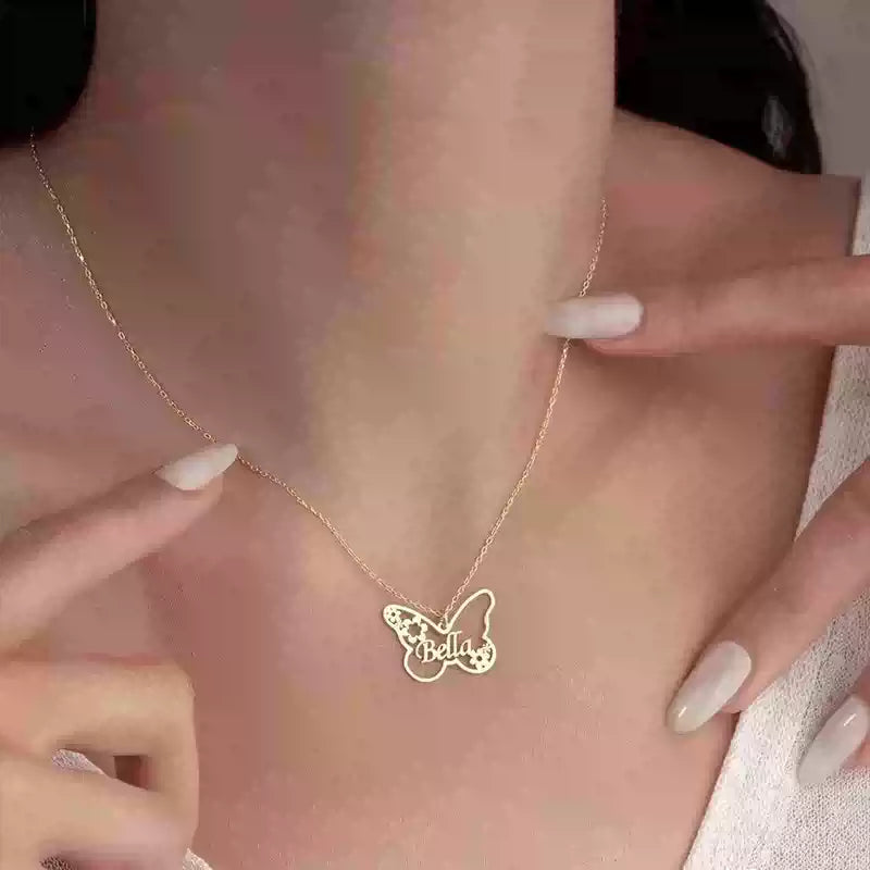 Butterfly-shaped necklace with 'Bella' on a person's neck against a pink background Stainless Steel Name Jewelry. Custom Gift-Personalized. gift for boyfriend / girlfriend. long-distance relationship gift meaningful keepsake. Memory gift. Christmas couple gift. Birthday Gift. Butterfly & Blossom Name Necklace