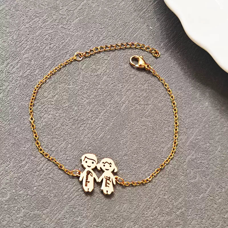 Gold bracelet with two small figures holding hands on a gray surface. Boy & Girl holding hands. Stainless Steel Name Jewelry. Custom Gift-Personalized. gift for boyfriend / girlfriend. long-distance relationship gift meaningful keepsake. Memory gift. Christmas couple gift. Birthday Gift. 