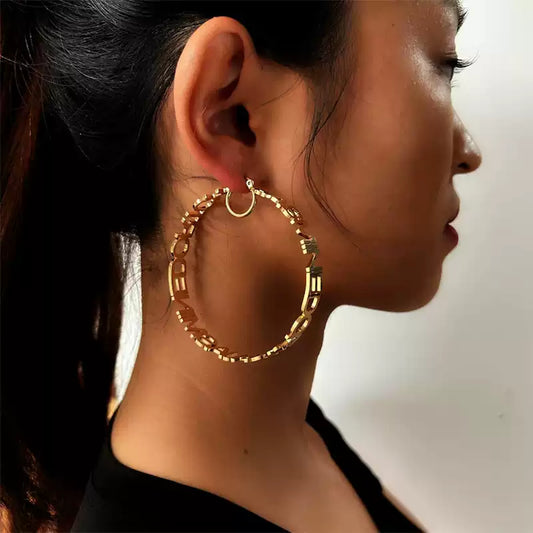 Close-up of a person wearing gold hoop earrings with a blurred background. Stainless Steel Name Jewelry. Custom Gift-Personalized. gift for boyfriend / girlfriend. long-distance relationship gift meaningful keepsake. Memory gift. Christmas couple gift. Birthday Gift. Statement Loop Name Earrings