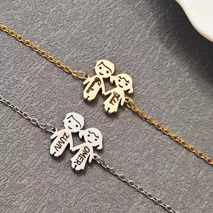 Two gold and silver necklaces with stick figure pendants on a textured surface. Boy & Girl holding hands. Stainless Steel Name Jewelry. Custom Gift-Personalized. gift for boyfriend / girlfriend. long-distance relationship gift meaningful keepsake. Memory gift. Christmas couple gift. Birthday Gift. 