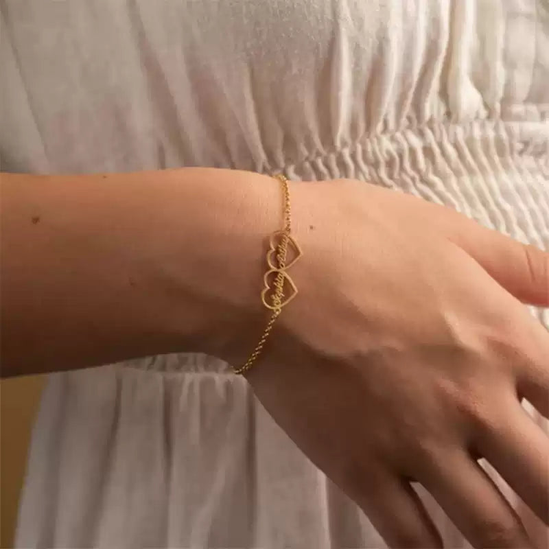 Gold bracelet with a heart design on a wrist against a neutral background. Double heart. Stainless Steel Name Jewelry. Custom Gift-Personalized. gift for boyfriend / girlfriend. long-distance relationship gift meaningful keepsake. Memory gift. Christmas couple gift. Birthday Gift. 