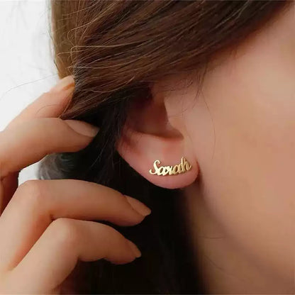 Gold 'Sarah' earring worn by a person. Stainless Steel Name Jewelry. Custom Gift-Personalized. gift for boyfriend / girlfriend. long-distance relationship gift meaningful keepsake. Memory gift. Christmas couple gift. Birthday Gift. Curved SoulName Earrings