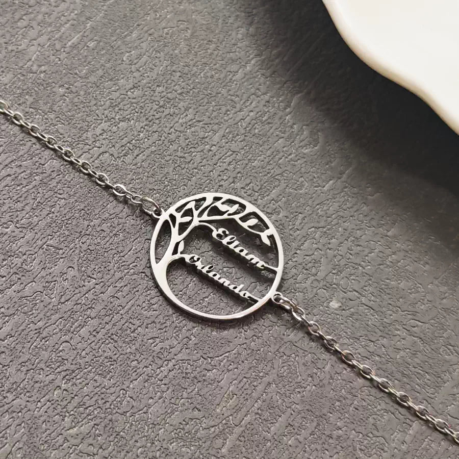 Silver bracelet with tree design and engraved names on a gray textured surface. Stainless Steel Name Jewelry. Custom Gift-Personalized. gift for boyfriend / girlfriend. long-distance relationship gift meaningful keepsake. Memory gift. Christmas couple gift. Birthday Gift. 