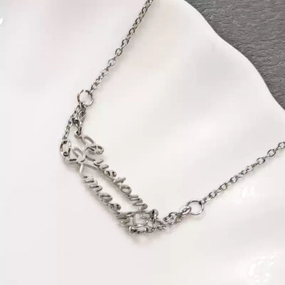 Silver necklace on a white cushion with a gray background. Stainless Steel Name Jewelry. Custom Gift-Personalized. gift for boyfriend / girlfriend. long-distance relationship gift meaningful keepsake. Memory gift. Christmas couple gift. Birthday Gift. 