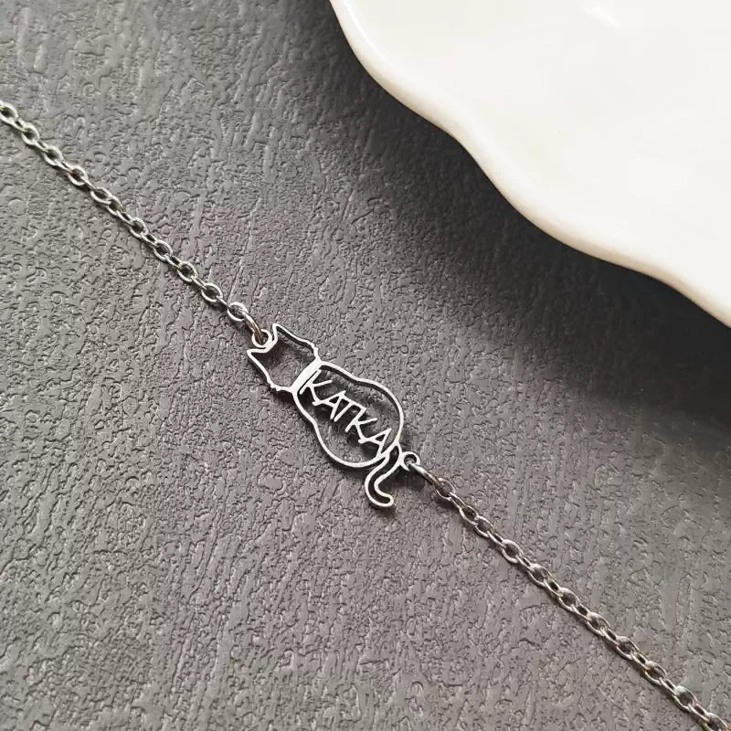 Silver cat-shaped nameplate necklace on a textured surface. Cat with name. Stainless Steel Name Jewelry. Custom Gift-Personalized. gift for boyfriend / girlfriend. long-distance relationship gift meaningful keepsake. Memory gift. Christmas couple gift. Birthday Gift. 