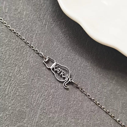 Silver cat-shaped nameplate necklace on a textured surface. Cat with name. Stainless Steel Name Jewelry. Custom Gift-Personalized. gift for boyfriend / girlfriend. long-distance relationship gift meaningful keepsake. Memory gift. Christmas couple gift. Birthday Gift. 