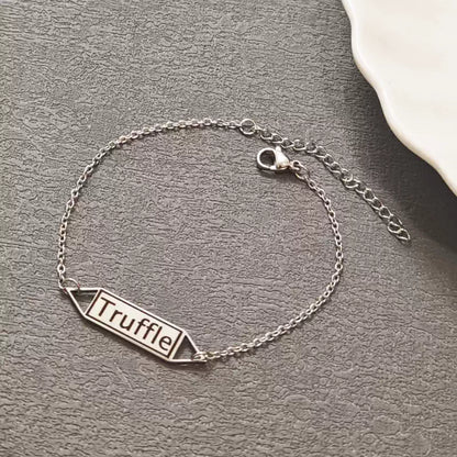 Silver bracelet with 'Truffle' tag on a gray surface. Hollow Plaque. Stainless Steel Name Jewelry. Custom Gift-Personalized. gift for boyfriend / girlfriend. long-distance relationship gift meaningful keepsake. Memory gift. Christmas couple gift. Birthday Gift. 