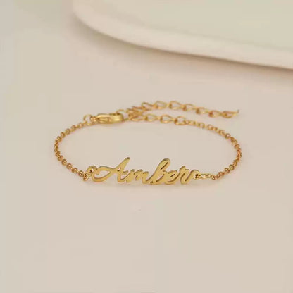 Gold bracelet with 'Amber' engraving on a beige background Stainless Steel Name Jewelry. Custom Gift-Personalized. gift for boyfriend / girlfriend. long-distance relationship gift meaningful keepsake. Memory gift. Christmas couple gift. Birthday Gift. 