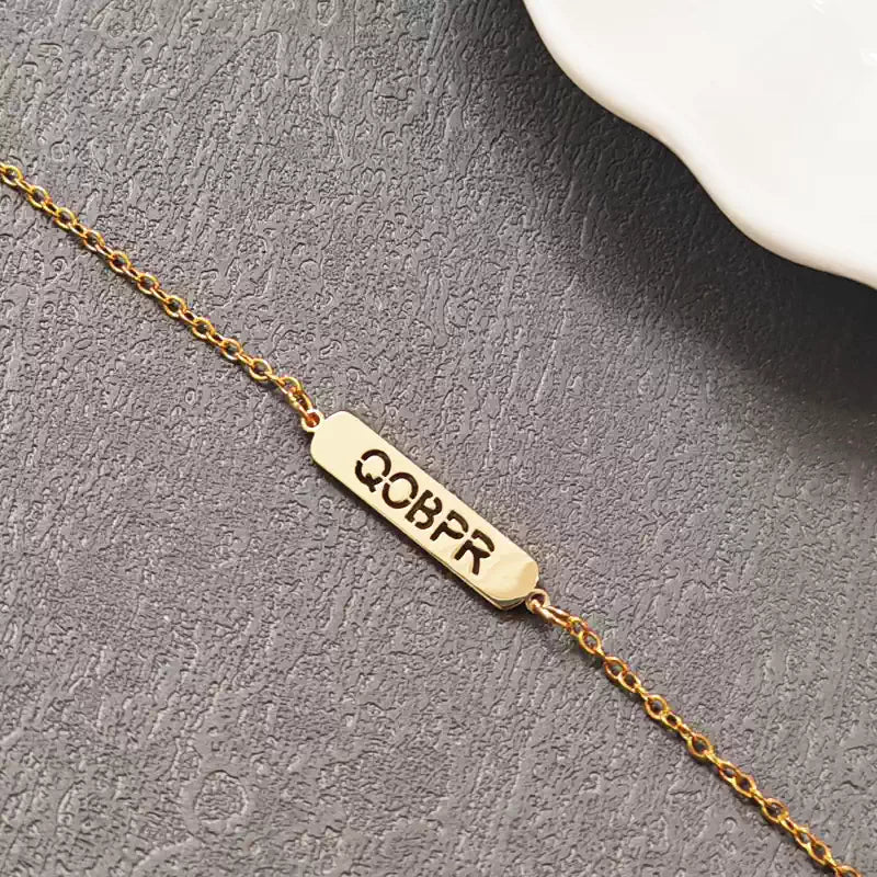 Gold bracelet with engraved letters on a gray surface. Hollow Plaque. Stainless Steel Name Jewelry. Custom Gift-Personalized. gift for boyfriend / girlfriend. long-distance relationship gift meaningful keepsake. Memory gift. Christmas couple gift. Birthday Gift. 