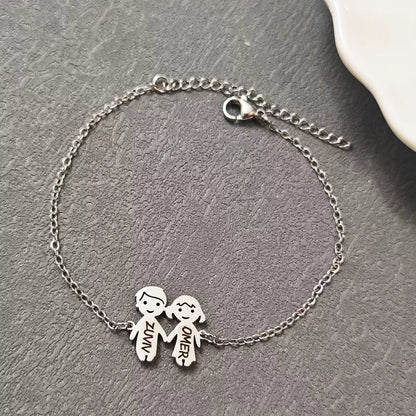Silver bracelet with two child charms on a gray surface. Boy & Girl holding hands. Stainless Steel Name Jewelry. Custom Gift-Personalized. gift for boyfriend / girlfriend. long-distance relationship gift meaningful keepsake. Memory gift. Christmas couple gift. Birthday Gift. 