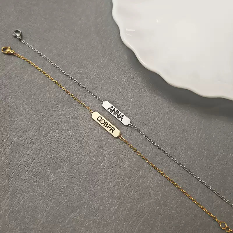 Gold and silver bracelet with engraved names on a gray surface. Hollow Plaque. Stainless Steel Name Jewelry. Custom Gift-Personalized. gift for boyfriend / girlfriend. long-distance relationship gift meaningful keepsake. Memory gift. Christmas couple gift. Birthday Gift. 