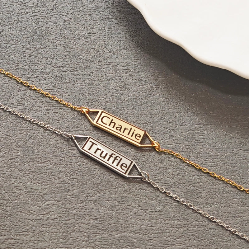 Two nameplate necklaces, one gold and one silver, on a gray surface. Hollow Plaque. Stainless Steel Name Jewelry. Custom Gift-Personalized. gift for boyfriend / girlfriend. long-distance relationship gift meaningful keepsake. Memory gift. Christmas couple gift. Birthday Gift. 