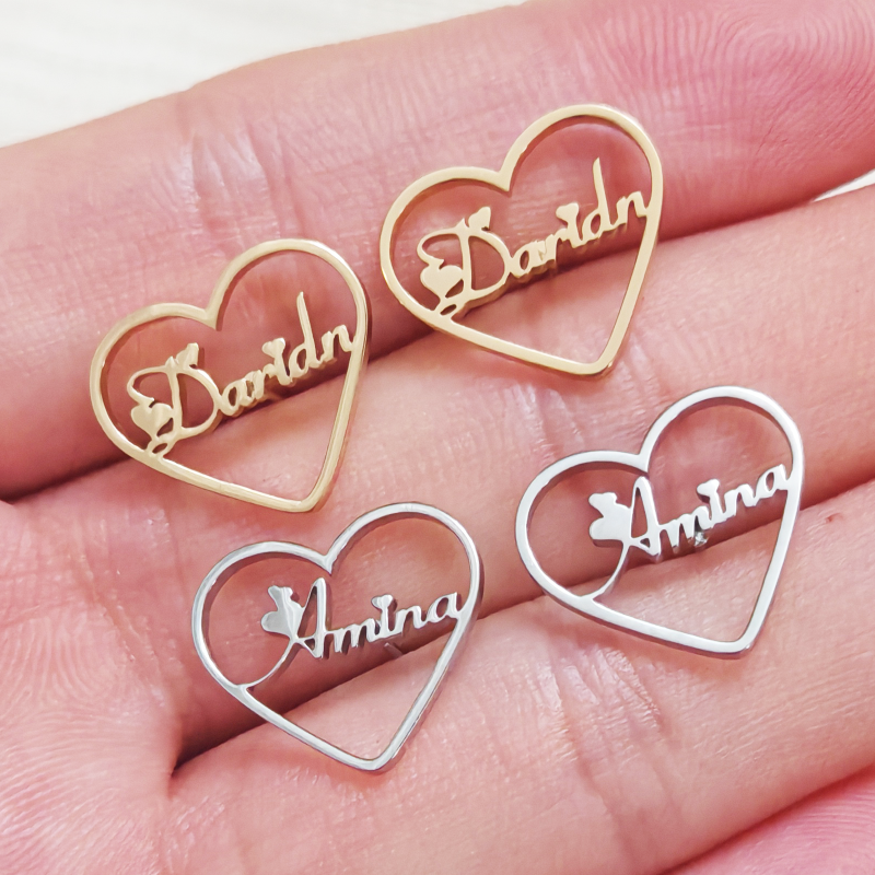 Heart-shaped earrings with engraved names on a hand Stainless Steel Name Jewelry. Custom Gift-Personalized. gift for boyfriend / girlfriend. long-distance relationship gift meaningful keepsake. Memory gift. Christmas couple gift. Birthday Gift. Heart Embrace Name Studs 