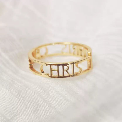 Gold ring with 'CHRIS' engraved on a white fabric background. Stainless Steel Name Jewelry. Custom Gift-Personalized. gift for boyfriend / girlfriend. long-distance relationship gift meaningful keepsake. Memory gift. Christmas couple gift. Birthday Gift. Bold Initial Frame