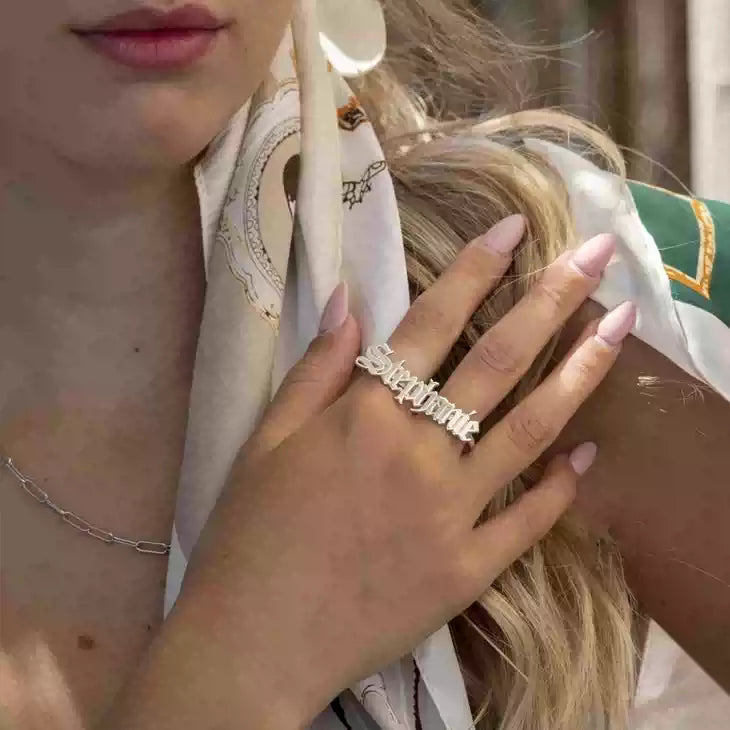Close-up of a hand wearing a silver ring with 'Sisterlove' on a blurred background. Double hole rings. Stainless Steel Name Jewelry. Custom Gift-Personalized. gift for boyfriend / girlfriend. long-distance relationship gift meaningful keepsake. Memory gift. Christmas couple gift. Birthday Gift. 