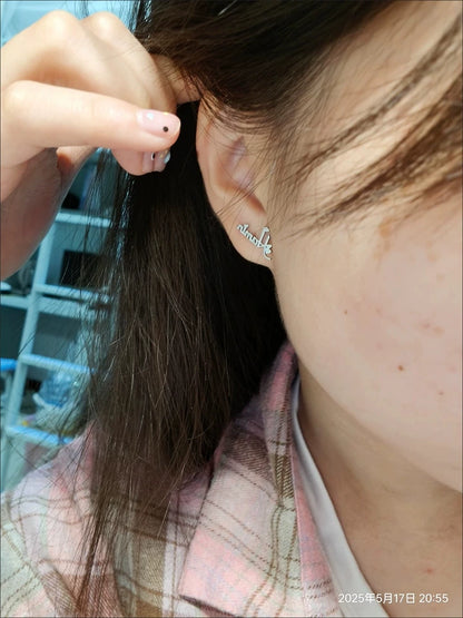 Close-up of a person wearing a silver earring with 'love' on it, outdoors. Stainless Steel Name Jewelry. Custom Gift-Personalized. gift for boyfriend / girlfriend. long-distance relationship gift meaningful keepsake. Memory gift. Christmas couple gift. Birthday Gift. Curved SoulName Earrings