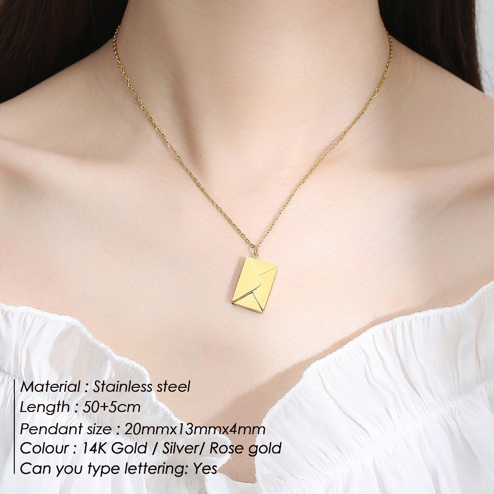 Gold necklace with a rectangular pendant on a person wearing a white top.