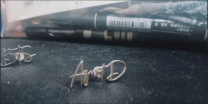 Silver earrings with 'AGNES' on a dark surface. Stainless Steel Name Jewelry. Custom Gift-Personalized. gift for boyfriend / girlfriend. long-distance relationship gift meaningful keepsake. Memory gift. Christmas couple gift. Birthday Gift. Curved SoulName Earrings