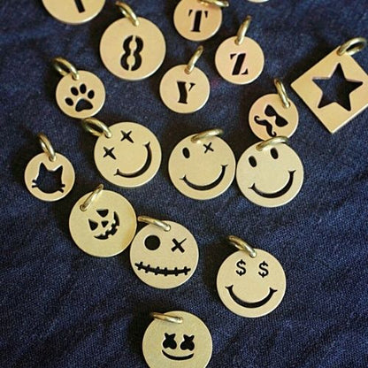 Collection of gold charms with various designs on a dark blue fabric background