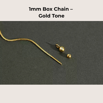 Gold box chain necklace with clasp on a dark gray background