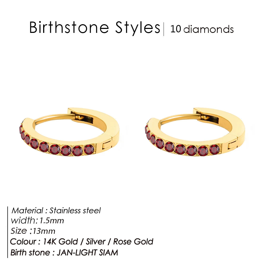 Gold hoop earrings with red gemstones on a white background