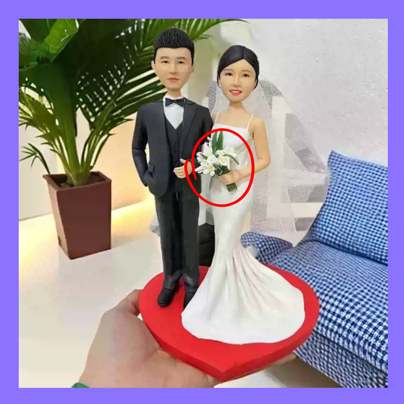 Wedding cake topper with a couple holding flowers, placed on a red heart-shaped stand. Accessories. Personalized couple present. Gift for boyfriend girlfriend. Custom-made. Personalized. Perfect gift idea. Meaningful keepsake. Wedding gift. Anniversary gift. Birthday gift