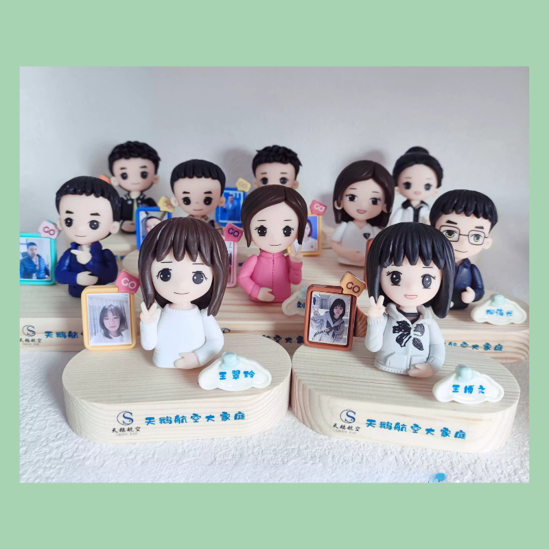 Collection of small figurines on a wooden base with a light green border.